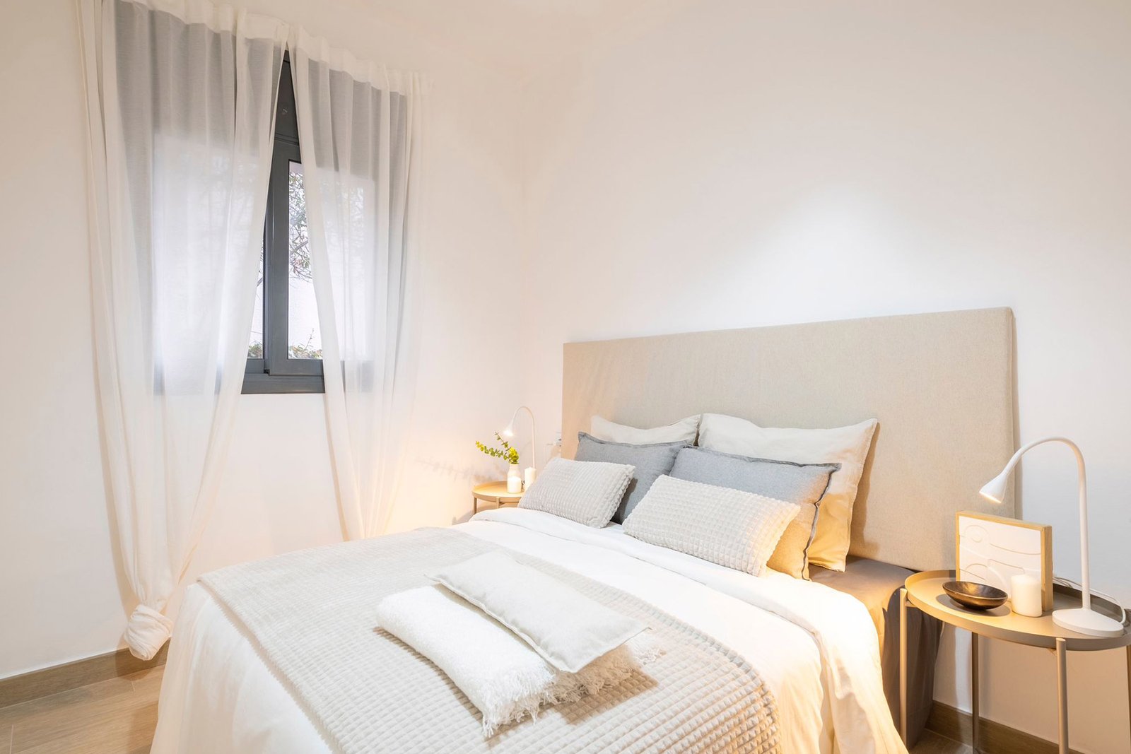Dormitorio con home staging profesional - textiles naturales e iluminación cálida para vender en Tarragona